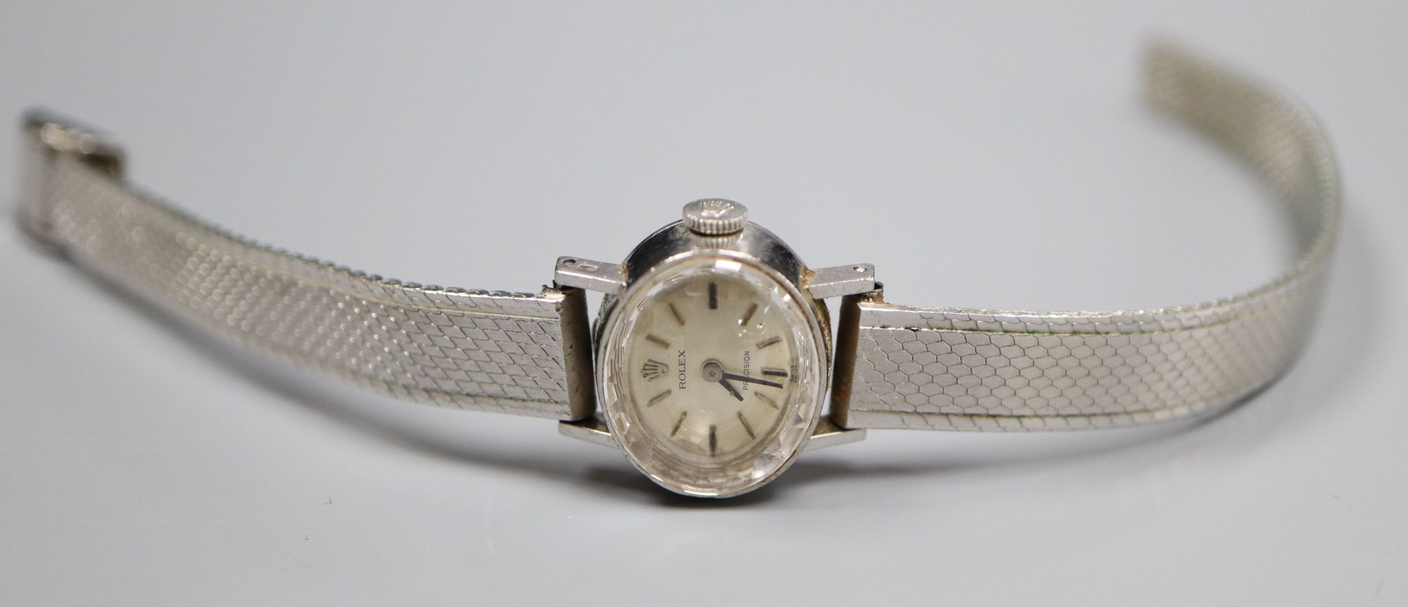 A ladys 18ct gold Rolex precision manual wind oval wrist watch, on a rhodium bracelet, overall 19cm, gross 26.8 grams.